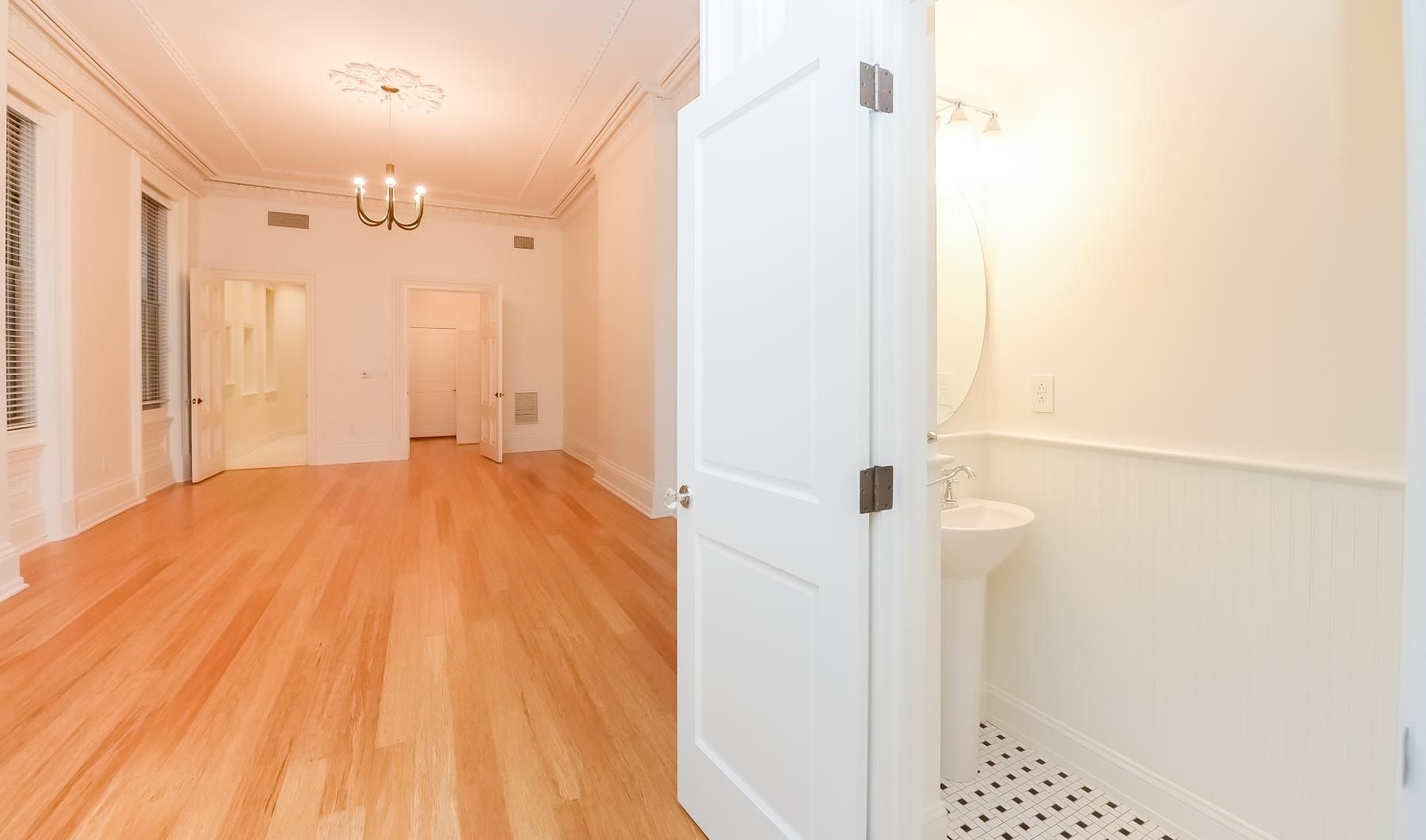 Wide open living areas perfect for entertaining a bathroom next to a living room with a wood floor