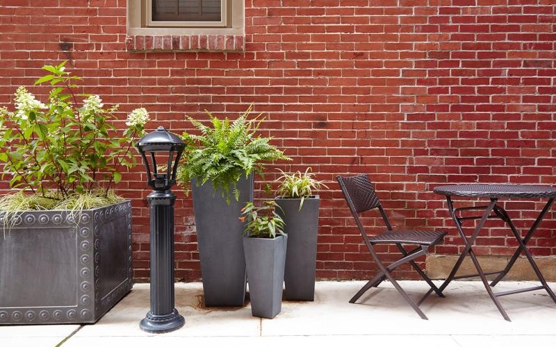 a table and chairs with potted plants outside